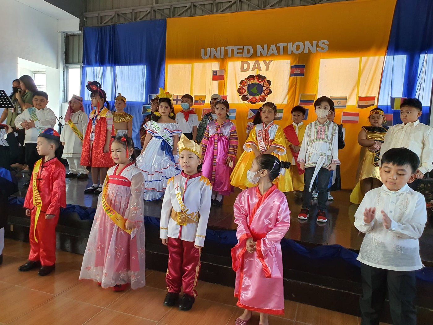 Younger pupils in national costume with their teachers